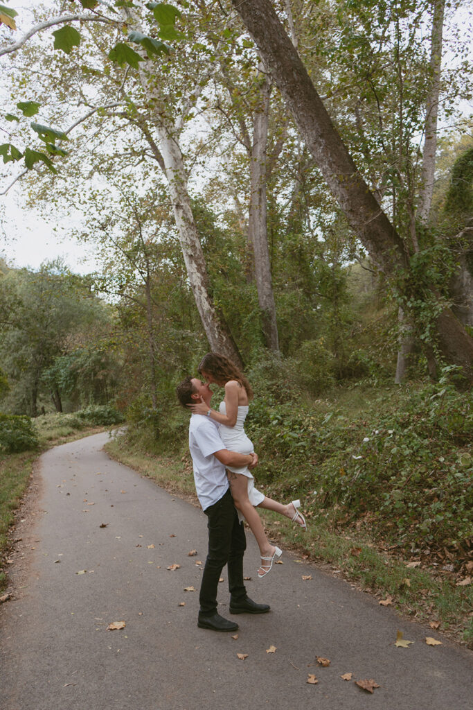 Man holds his fiancé up and twirls her 
