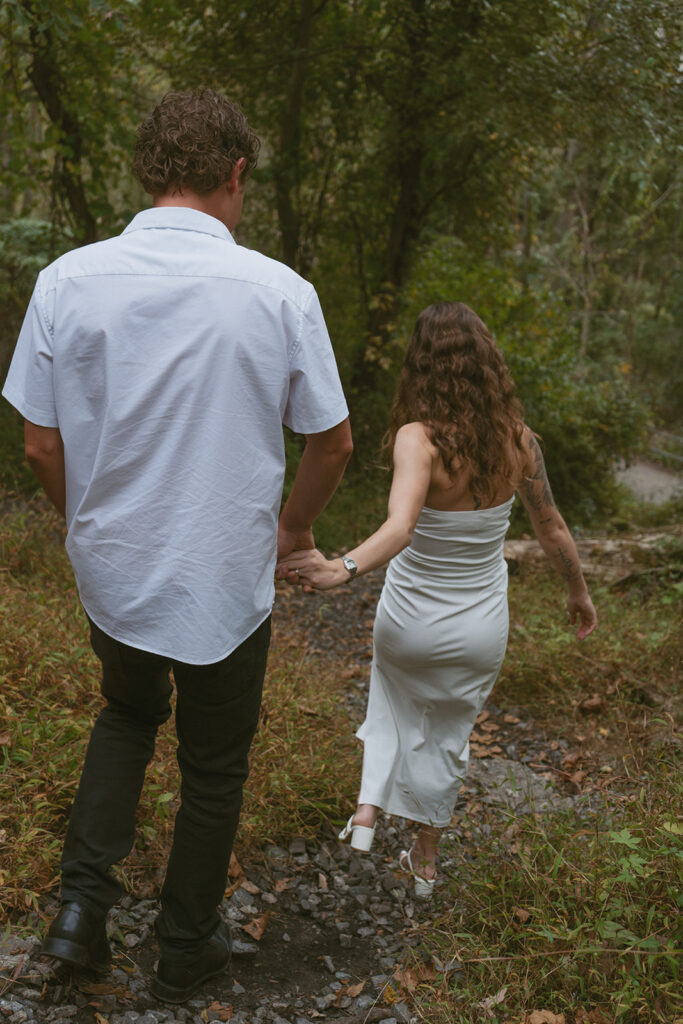 engaged couple holding hands walking down a path in Maryland