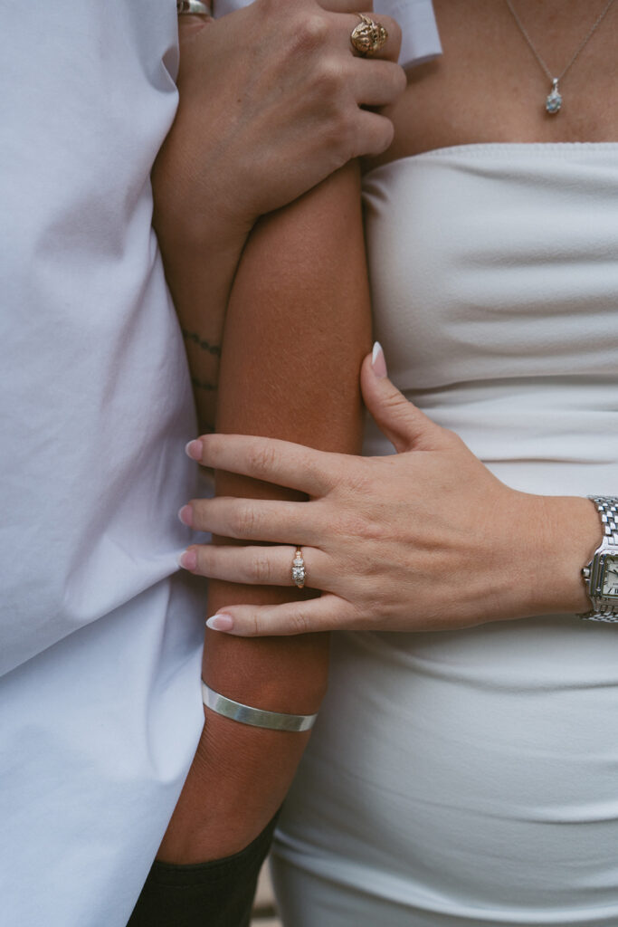 Engaged couple embracing, showing her engagement ring